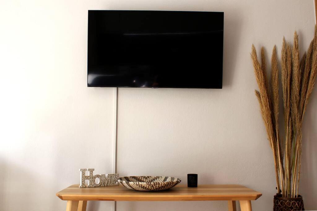 希俄斯inHeart Apartment Chios的挂在桌子上墙上的电视