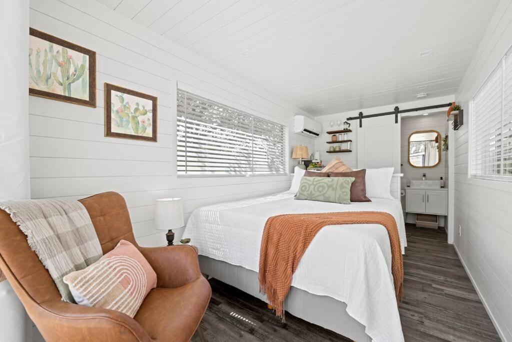弗雷德里克斯堡New The Saguaro-Tiny Shipping Container Home的白色卧室配有床和椅子