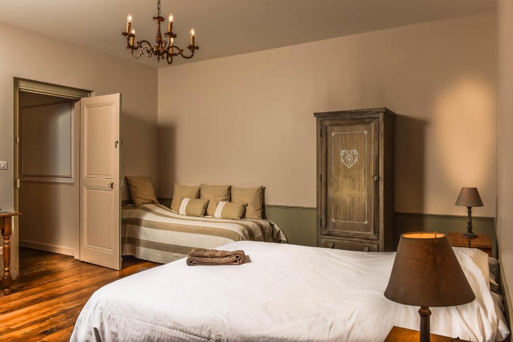 圣梅内乌勒德莫尔达贡住宿加早餐旅馆的一间卧室配有两张床和吊灯。