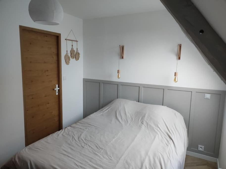 Beaussais sur MerCharmant appartement的卧室配有白色的床和木门