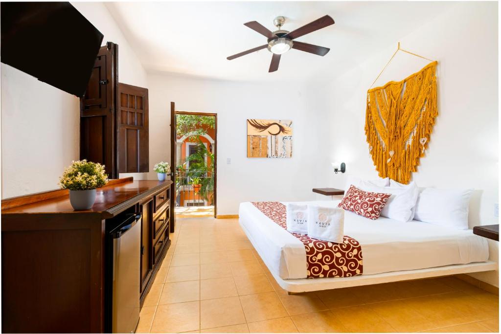 普拉亚卡门卡萨代拉斯弗洛雷斯酒店的客厅配有白色沙发和吊扇