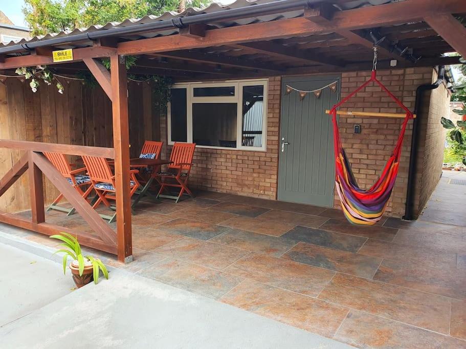 凯辛兰DOG FRIENDLY little bungalow with patio & private driveway的天井设有吊床,挂在房子里