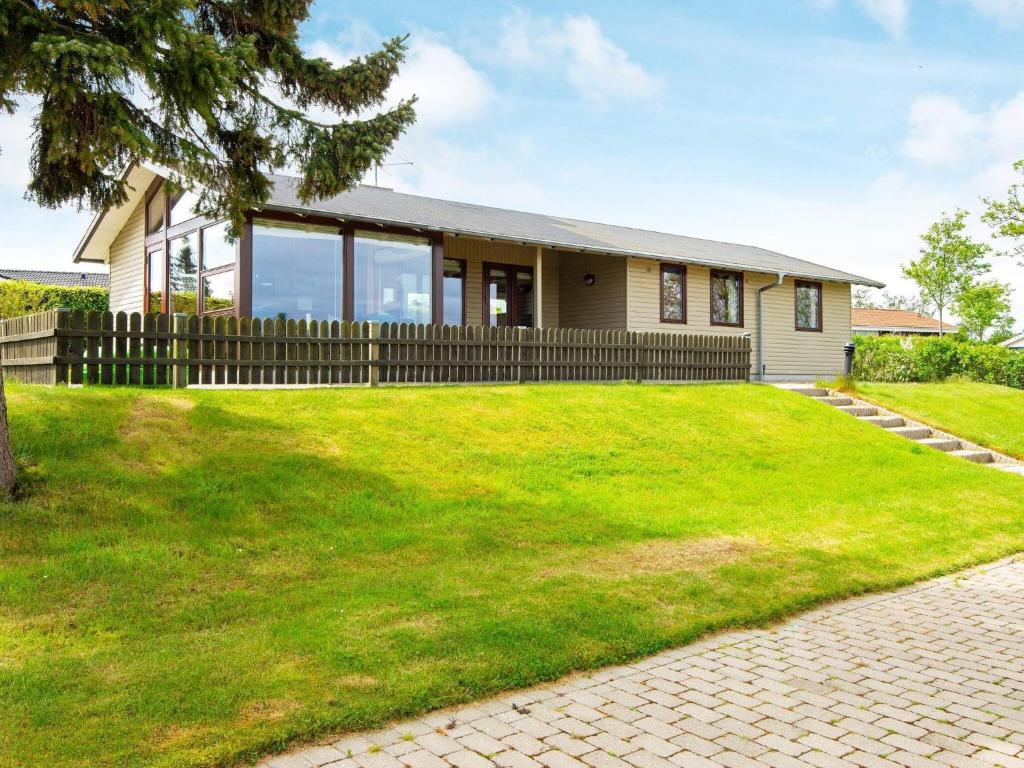森讷比5 person holiday home in Juelsminde的前面有绿色草坪的房子