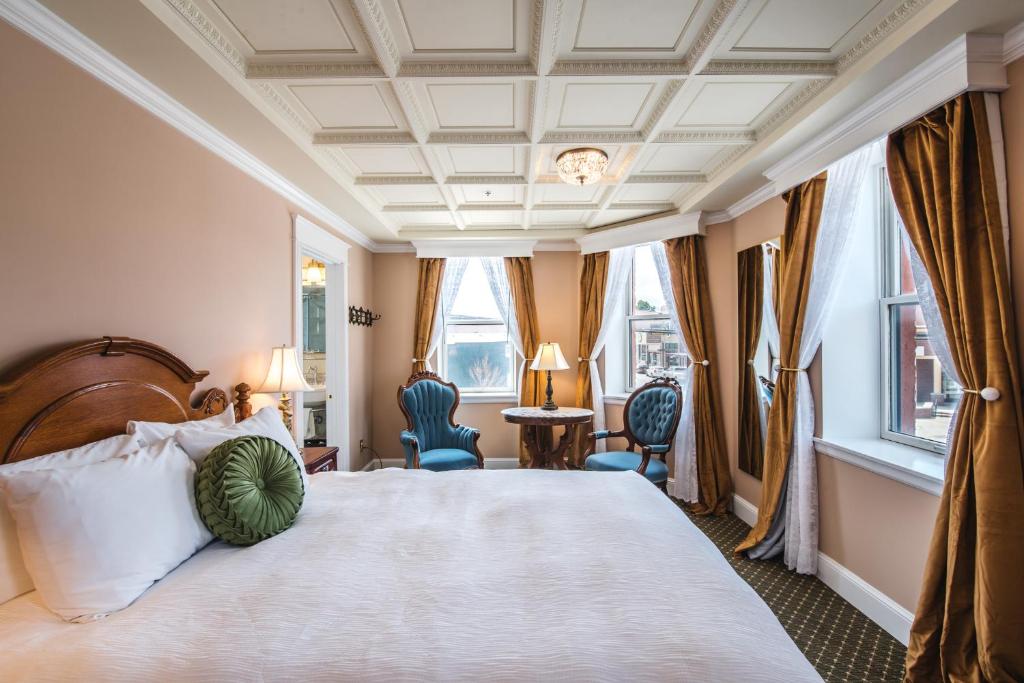 雷德洛治波拉德酒店的一间卧室配有一张大床、两把椅子和窗户。