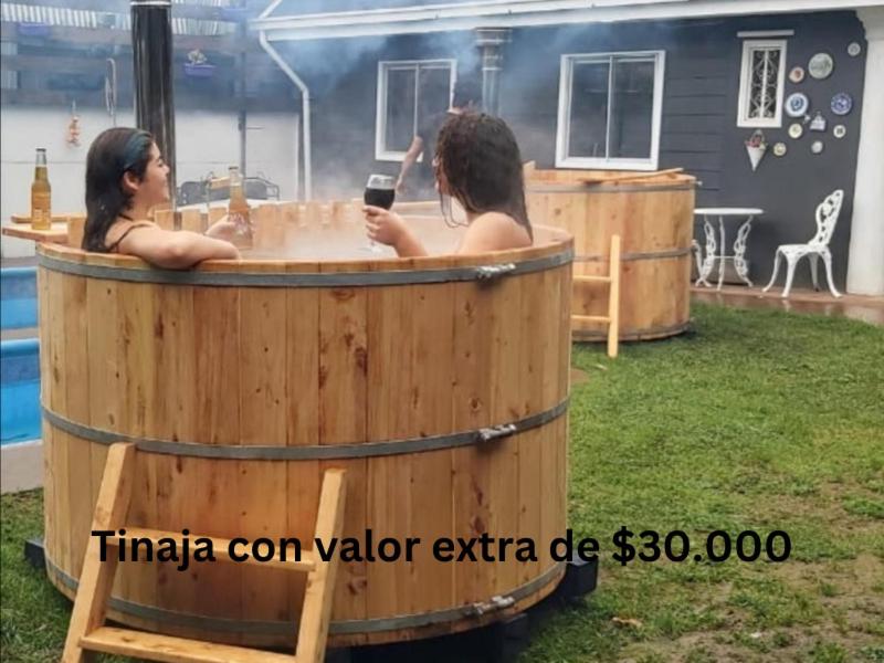 瓦尔迪维亚CABAÑA 2 TINAJA-PISCINA-QUINCHO的两个女人在院子里的桶里热水浴缸里