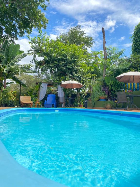 伊瓜苏Pequeno Paraíso的一个带遮阳伞的大型蓝色游泳池