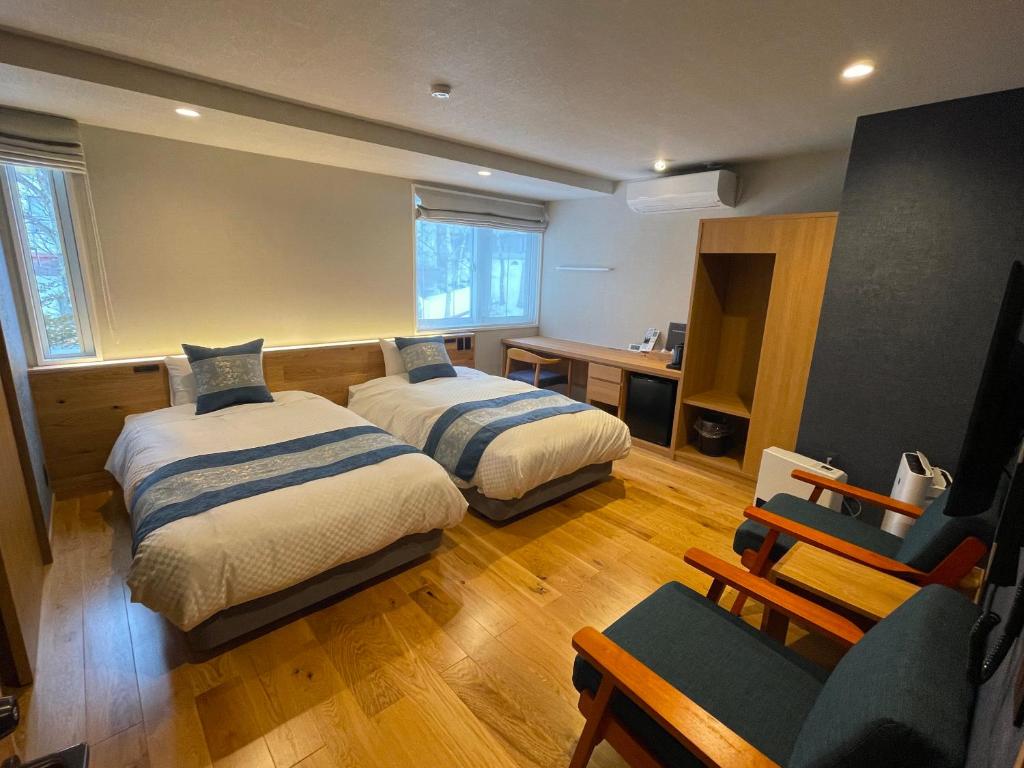 茅野小水鸟酒店的酒店客房,配有两张床和椅子