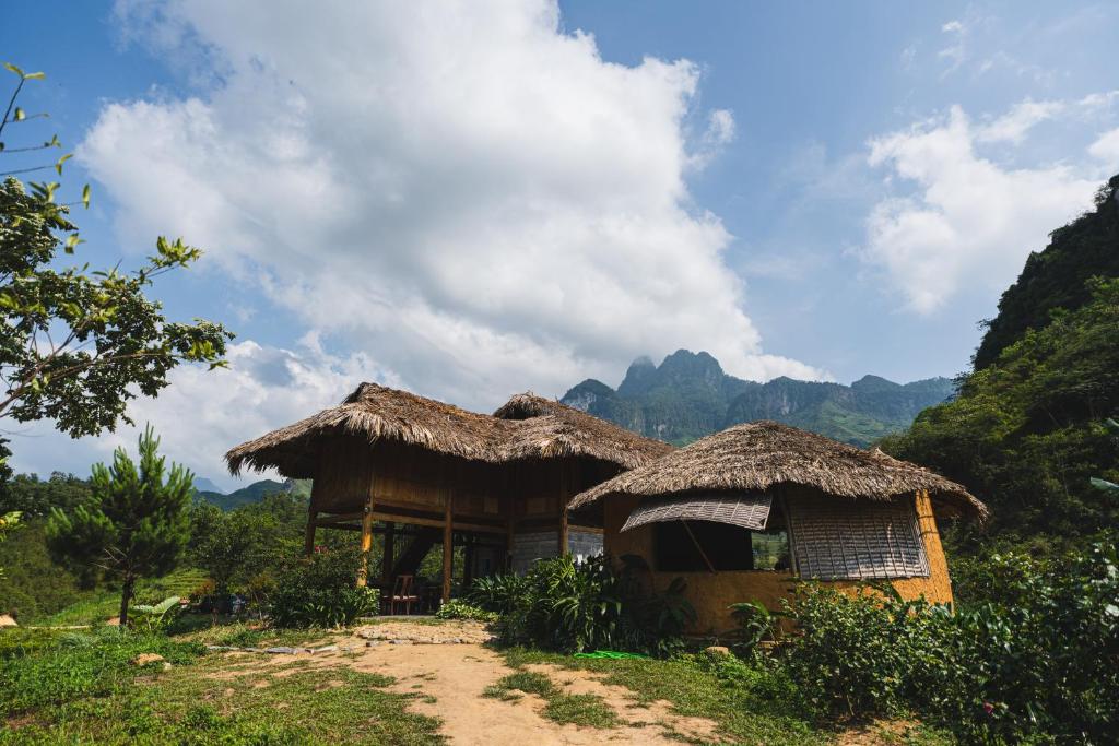 Làng CacTớ Dày Du Già Village的山上带草屋顶的小屋