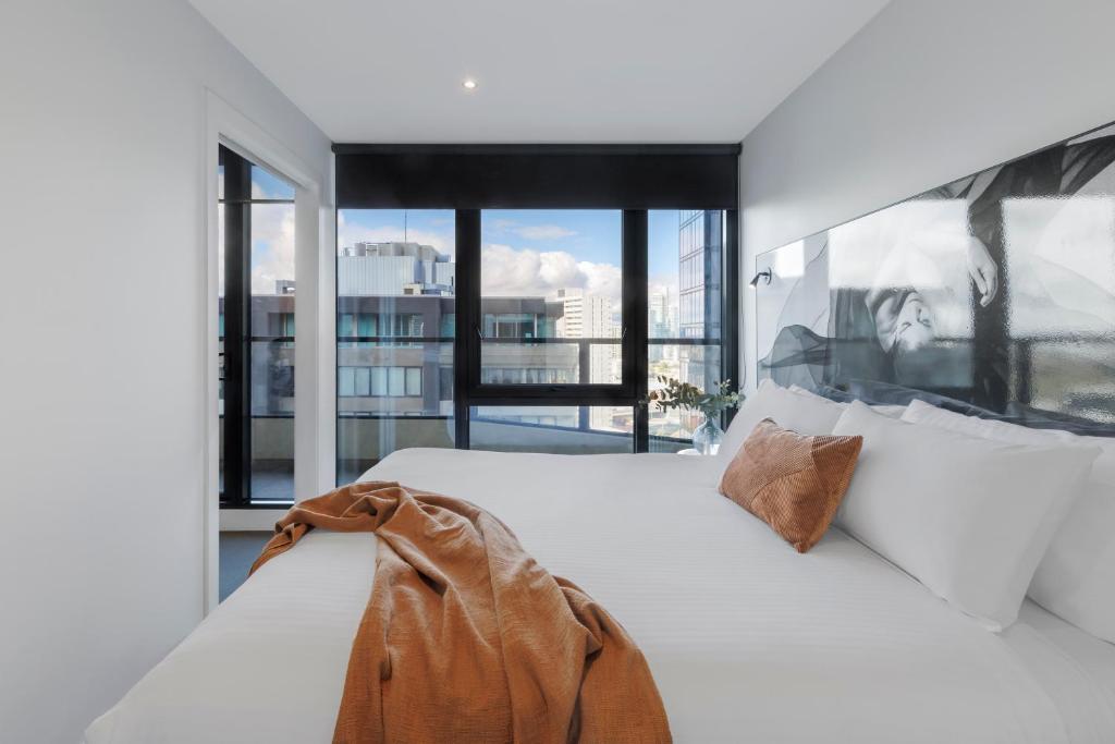 墨尔本Imagine Southbank的卧室配有白色的床和大窗户