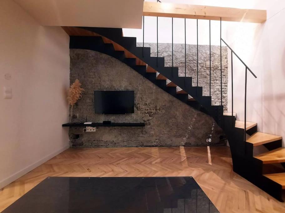 TrnávkaBuda-city house的一间带楼梯和电视的客厅
