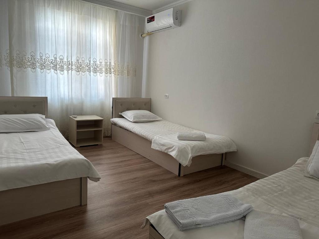 塔什干GUESTO HOSTEL的客房设有两张床和窗户。