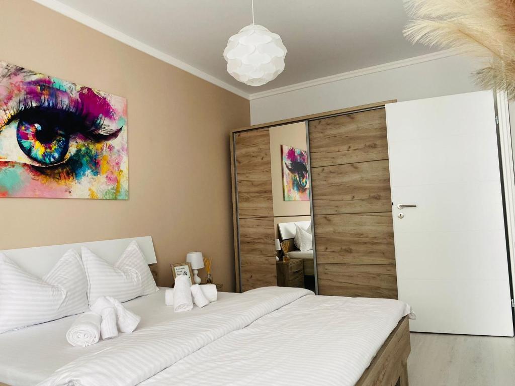 奥拉迪亚Adam Residence的卧室配有一张床,墙上挂有绘画作品