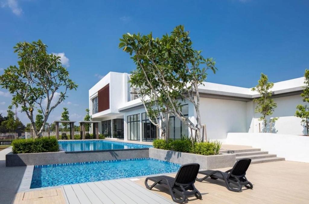 甘榜龙溪EZHomestay Platinum near Cyberjaya Putrajaya KLIA的一座带游泳池和两把椅子的房子