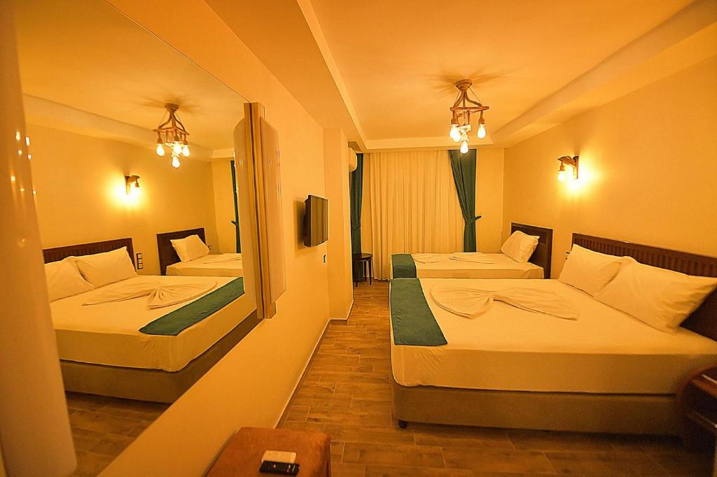MidyatMİDYAT LADİNOS OTEL的酒店客房,设有两张床和镜子
