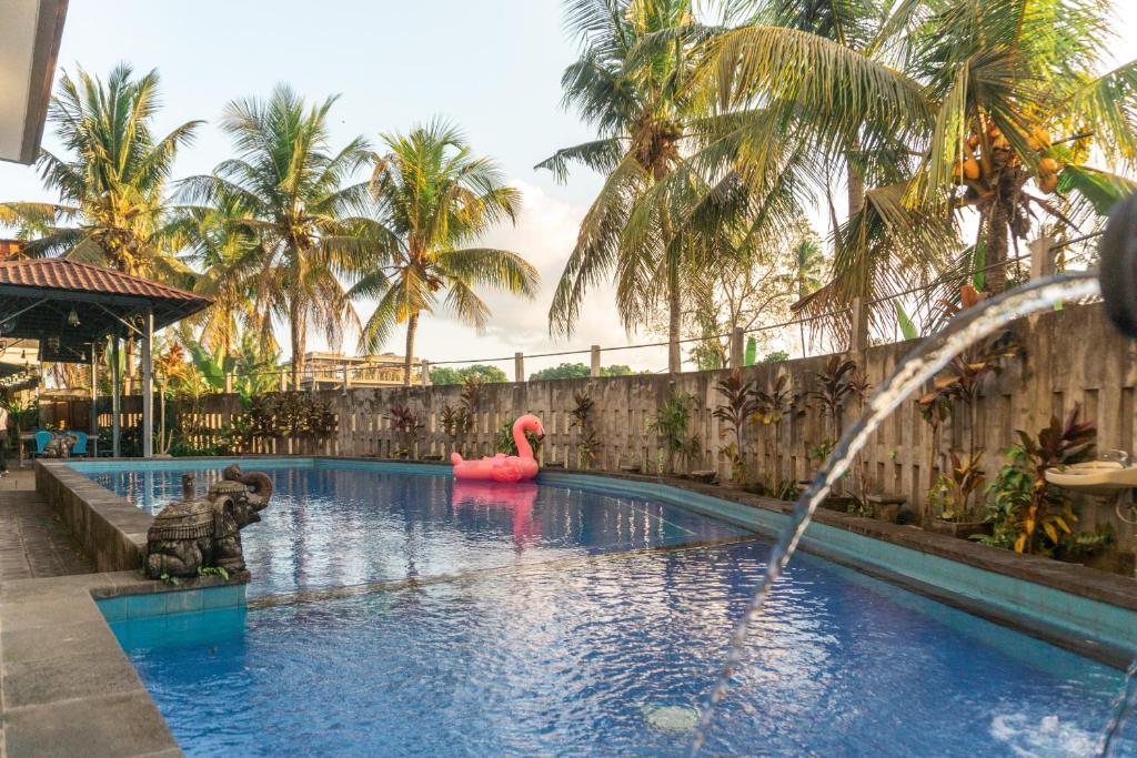 乌布Townhouse, Pool & Kitchen, Ubud, Cucus Mondok的一个带粉红色天鹅和火烈鸟的游泳池