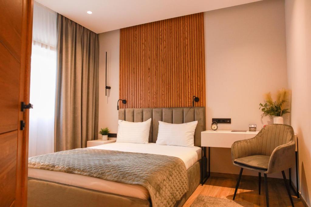 马拉加Apart-hotel Dream的一间卧室配有一张床、一张桌子和一把椅子