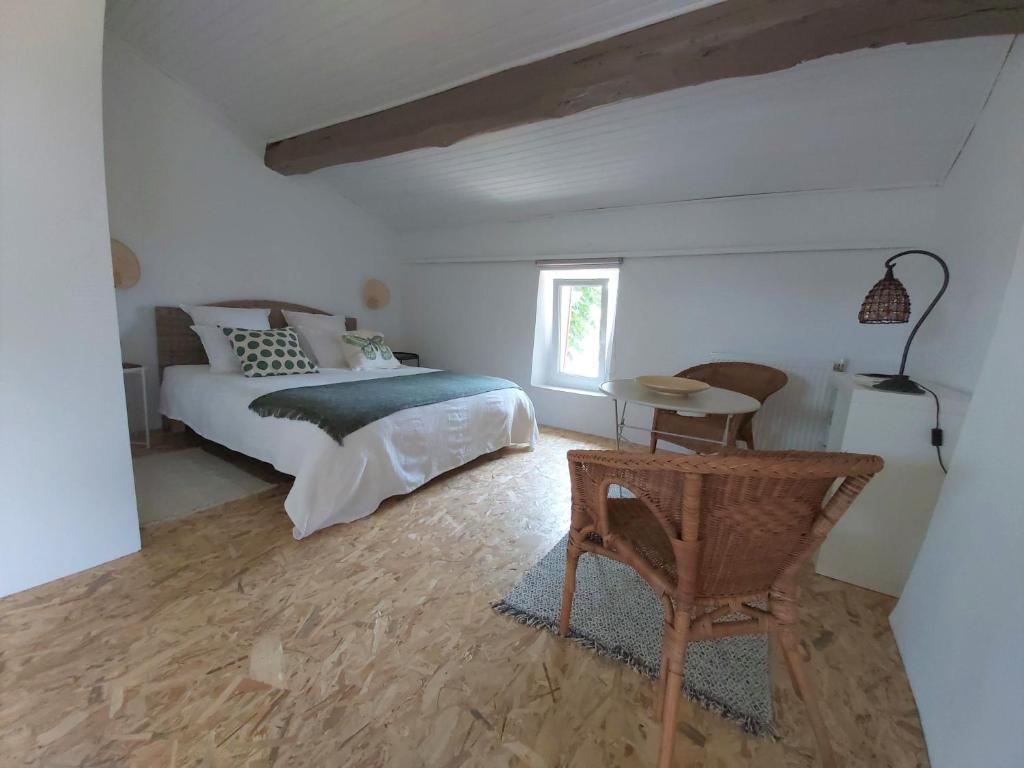 Jau-Dignac-et-LoiracRavissant studio à la ferme avec piscine的卧室配有1张床、1张桌子和1把椅子