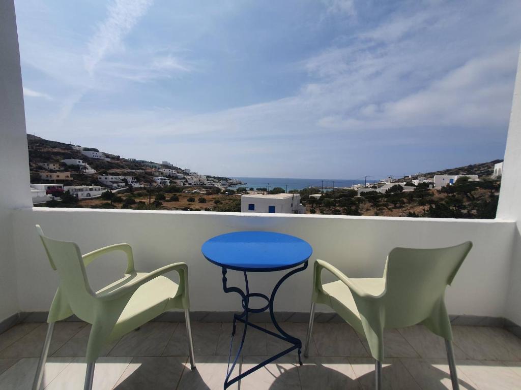 锡基诺斯岛Galini Rooms Sikinos Travel的阳台配有蓝色的桌子和两把椅子