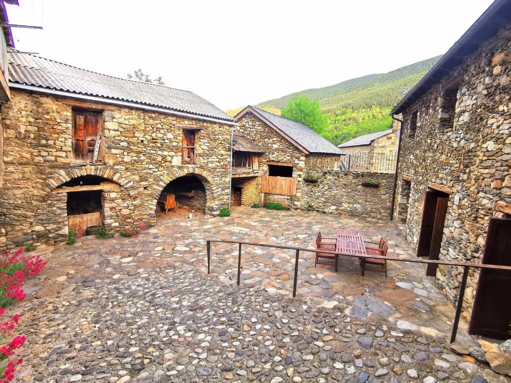 CardetTríplex con patio y BBQ en La Vall de Boí的庭院内带长凳的石头建筑