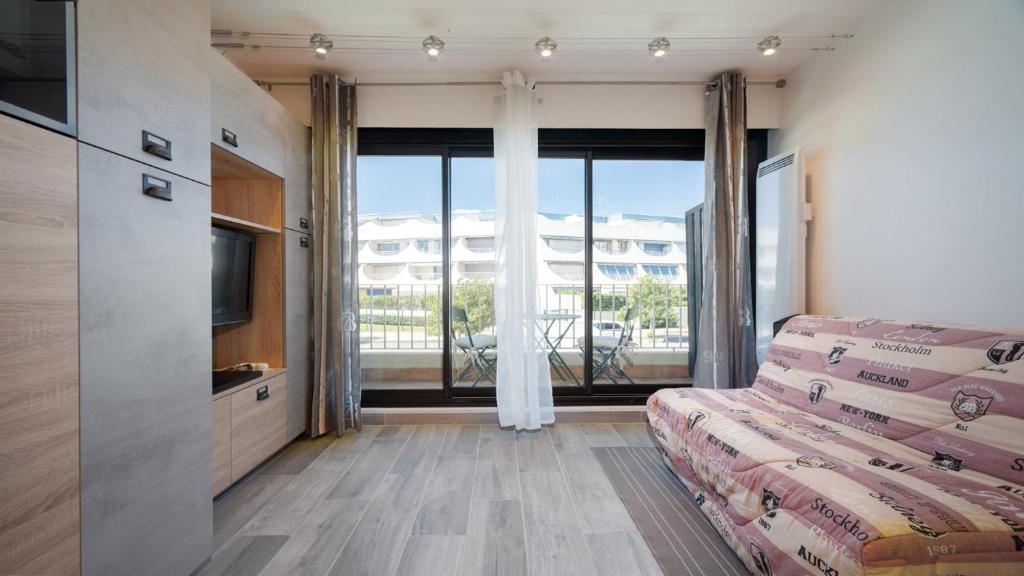 勒格罗-迪鲁瓦Terrasses de l Espiguette 320 - Studio 2 pers的客房设有床和大窗户。