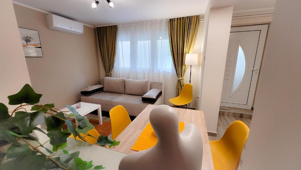 索科矿泉村Vila Nikola的客厅配有桌子和黄色椅子