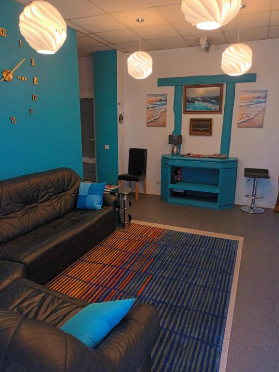 文茨皮尔斯Jūras Vilks的带沙发和蓝色墙壁的客厅