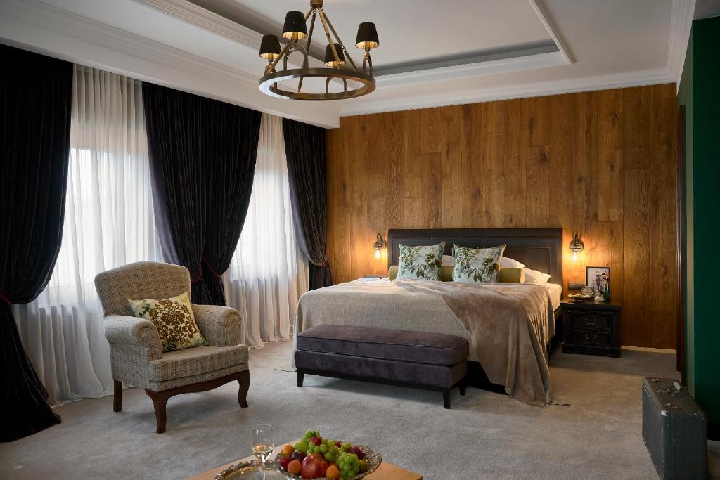 陶尔曹尔Andrássy Kúria & Spa的配有一张床和一把椅子的酒店客房
