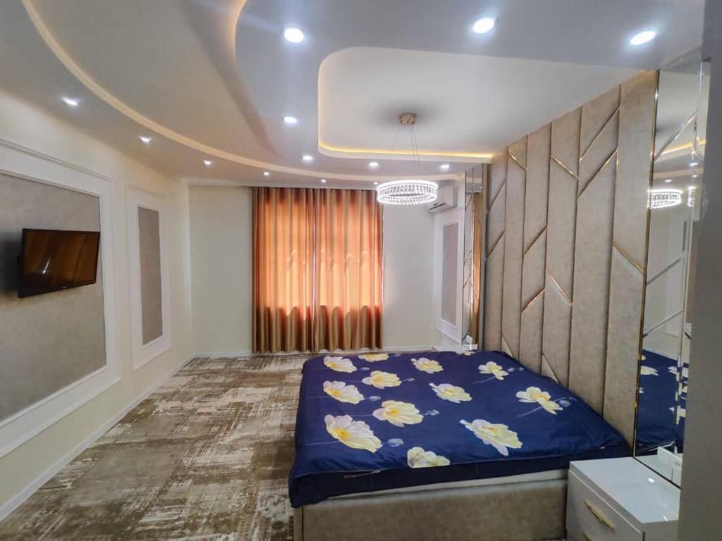 苦盏Golden Apartments的一间卧室配有一张带鲜花的蓝色床