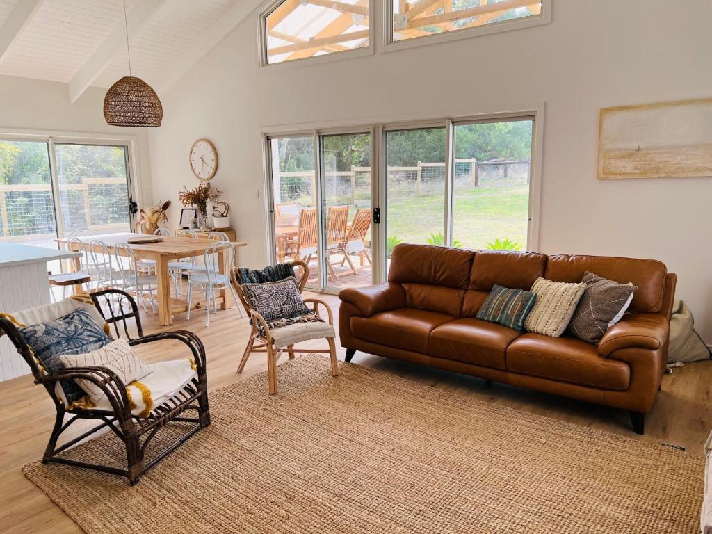 罗布Bluebird Days - Pet Friendly的客厅配有棕色真皮沙发和椅子