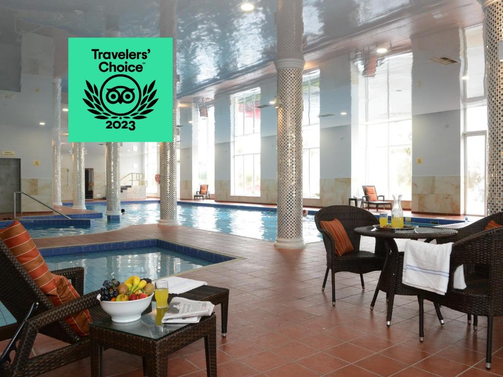 莱特肯尼克兰尼酒店及娱乐中心的酒店大堂设有游泳池、桌子和椅子