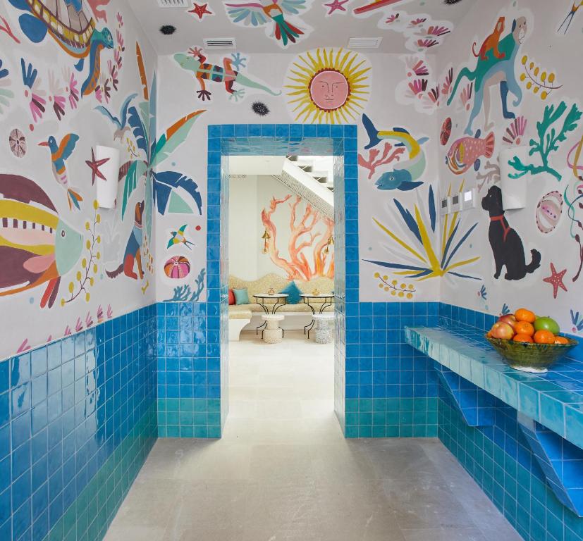 塔里法El Escondite Tarifa的浴室铺有蓝色瓷砖,墙上有动物