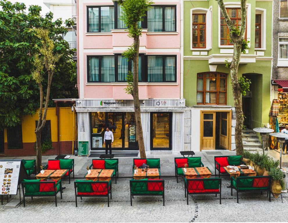 伊斯坦布尔Tin Suites的一组桌子和椅子,位于大楼前