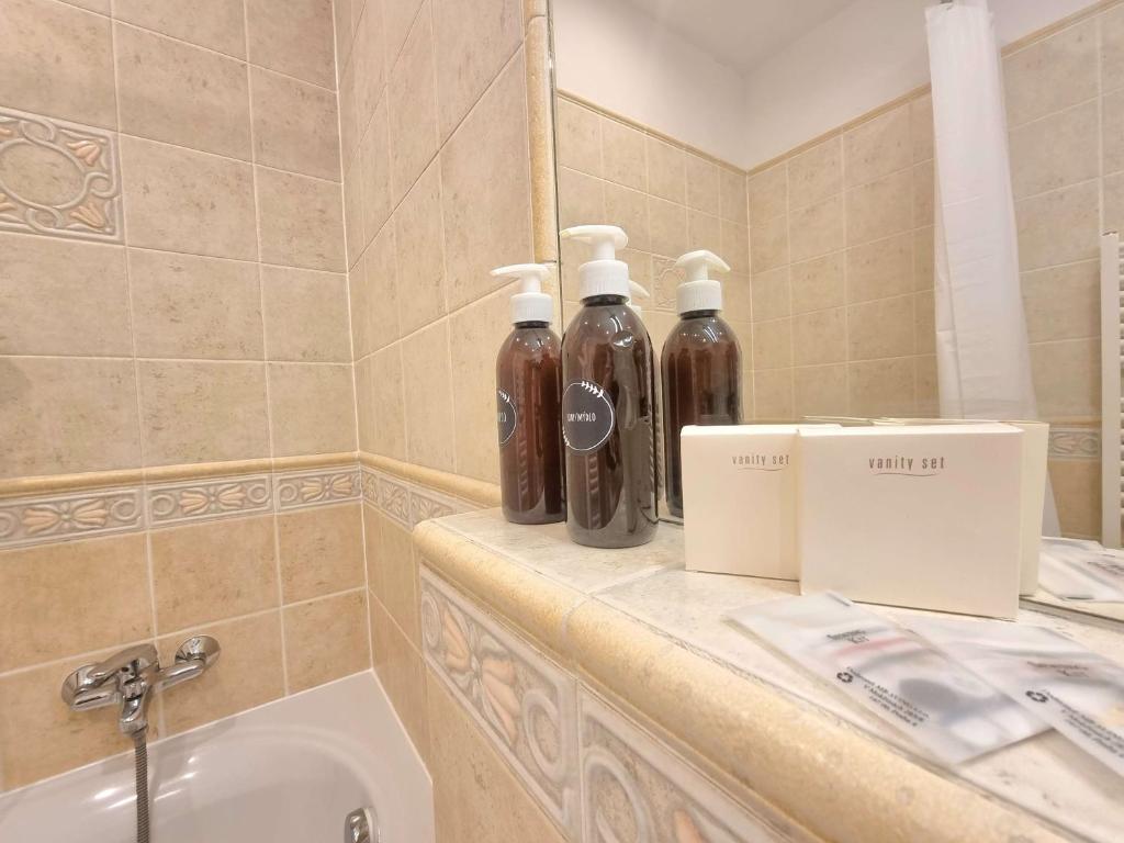布拉格克拉里斯酒店的盥洗盆旁的柜台上的浴室,配有2瓶水