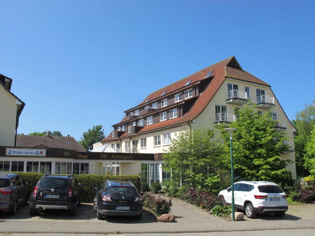 高尔维茨Apartment FIP-Ferienpark - Insel Poel-1 by Interhome的停车场内有车辆的建筑物