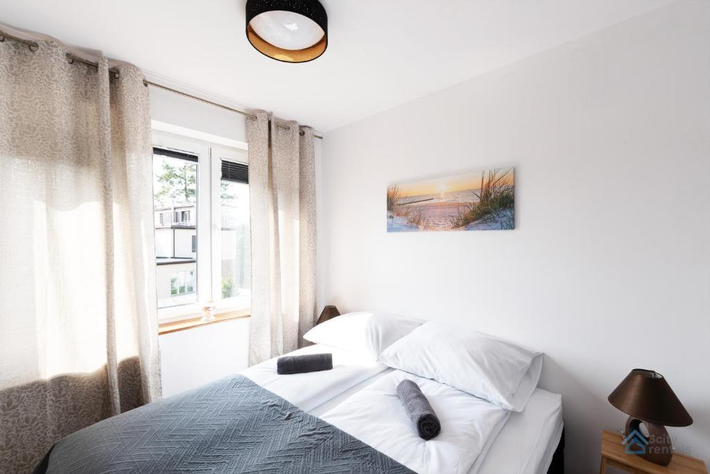格丁尼亚Uroda Morza by 3City Rentals的白色的卧室设有床和窗户