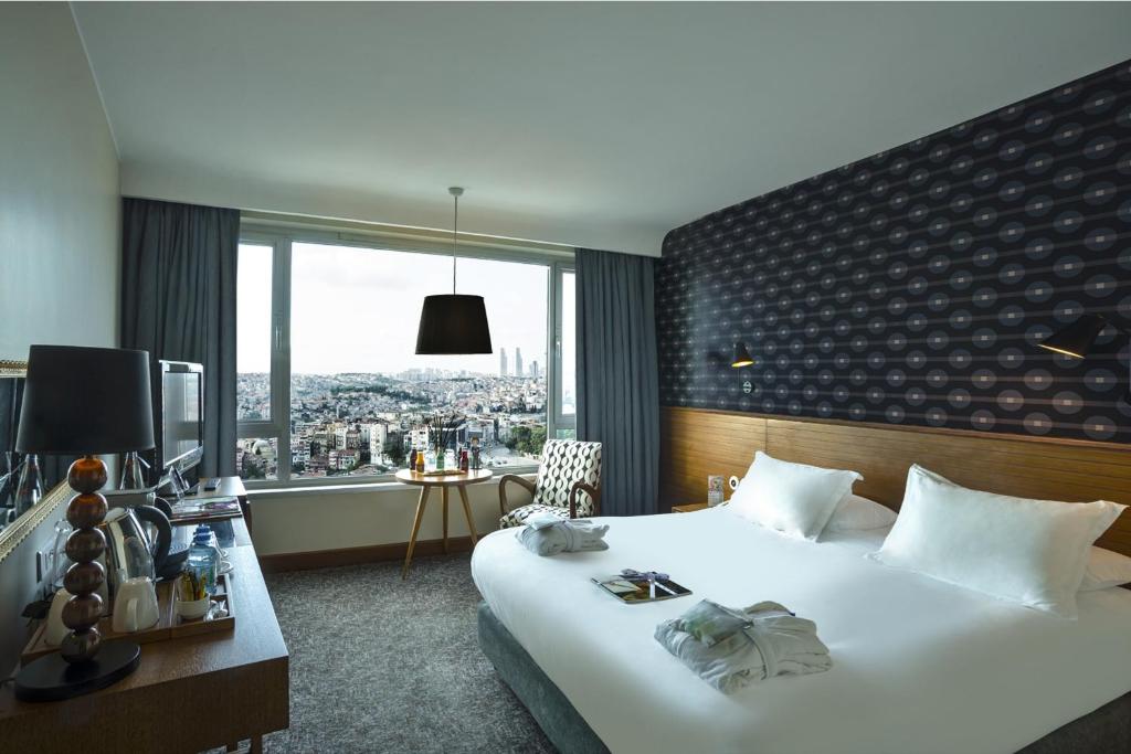 伊斯坦布尔马尔马拉佩拉酒店的酒店客房设有一张床和一个大窗户
