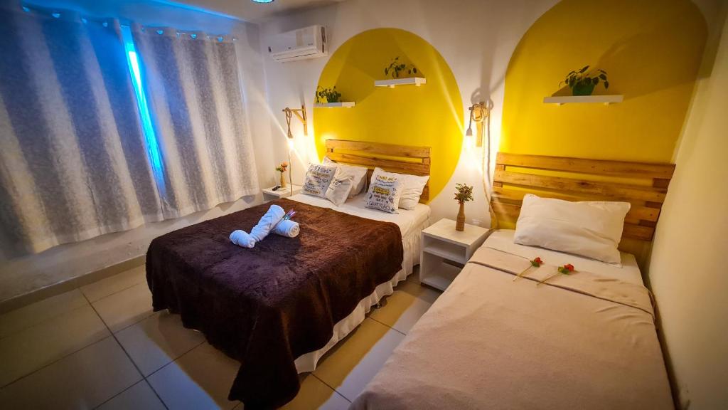 嘎林海斯港Cantinho da Gê Suítes的一间卧室配有两张床和镜子