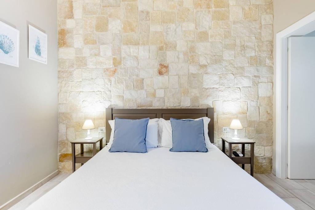 特拉尼Torrelama Room & Breakfast的一间卧室配有一张带蓝色枕头的大床