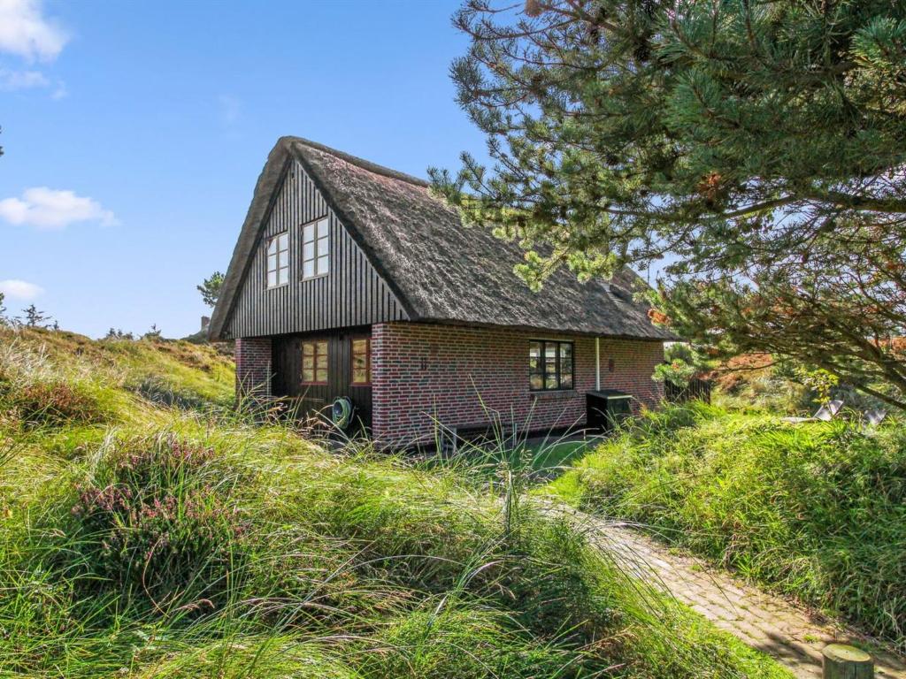 瓦伊厄斯斯特兰德Holiday Home Grita - 500m from the sea in Western Jutland by Interhome的山坡上的小砖屋,有树