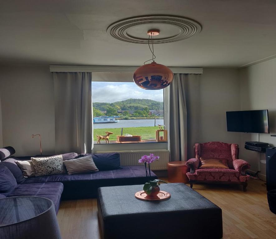 卡尼De Koperen Geit的客厅配有紫色沙发和窗户
