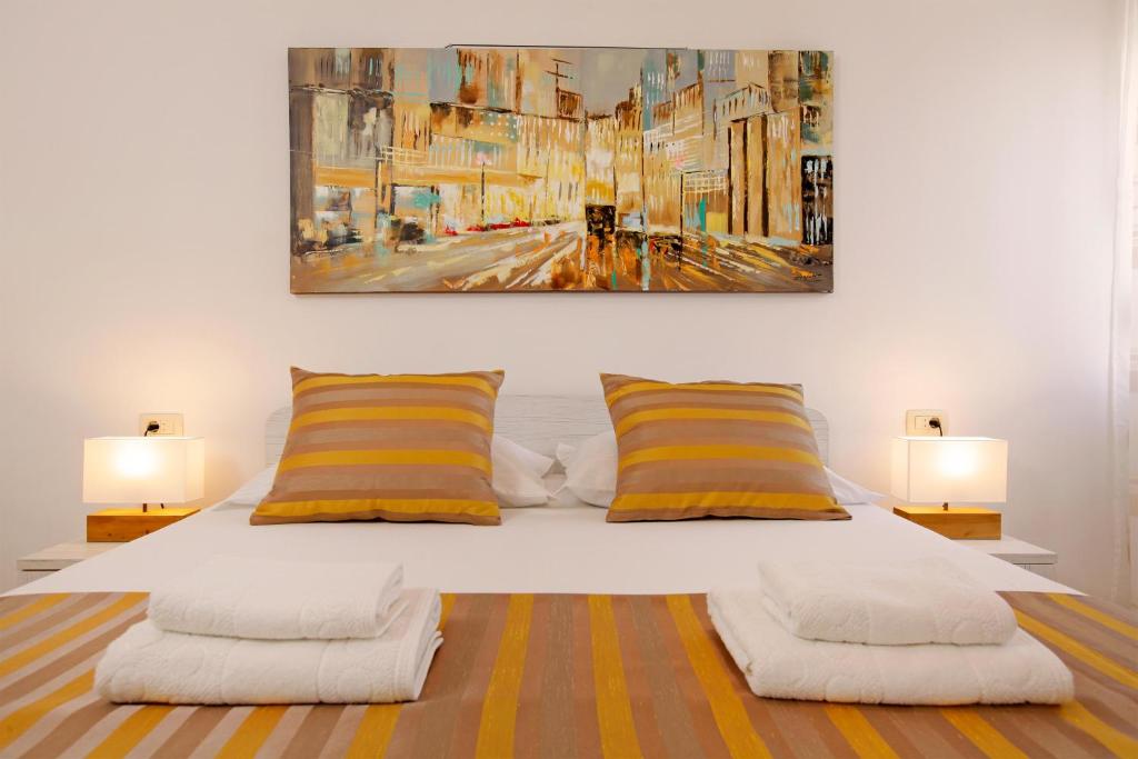 斯普利特Modern 2-Bed Apt, Late check in available的一张带黄色和白色枕头的床和绘画