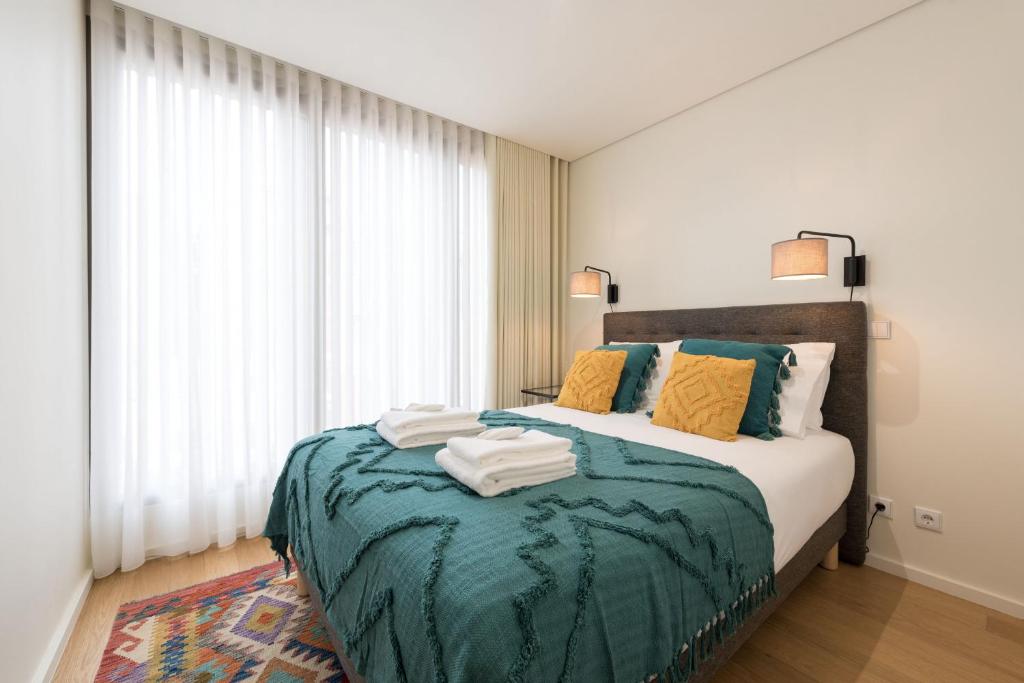波尔图AgapeStay Family House的一间卧室配有一张带绿毯的床