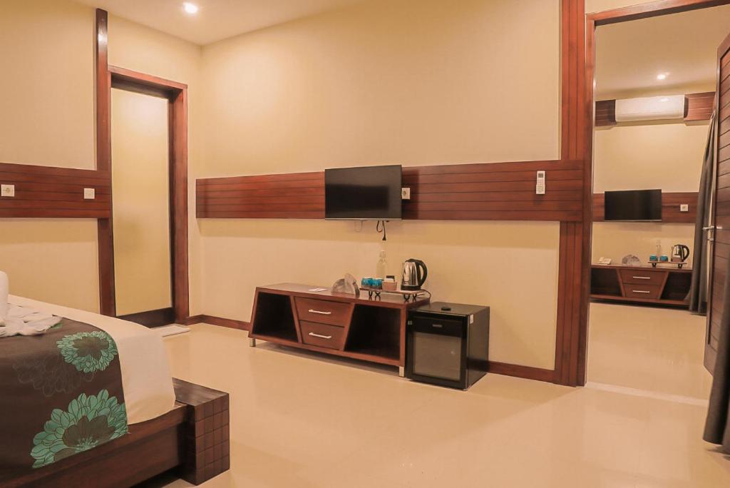 吉利特拉旺安Taj Maza Sunset Villas的卧室配有一张床,墙上配有电视。