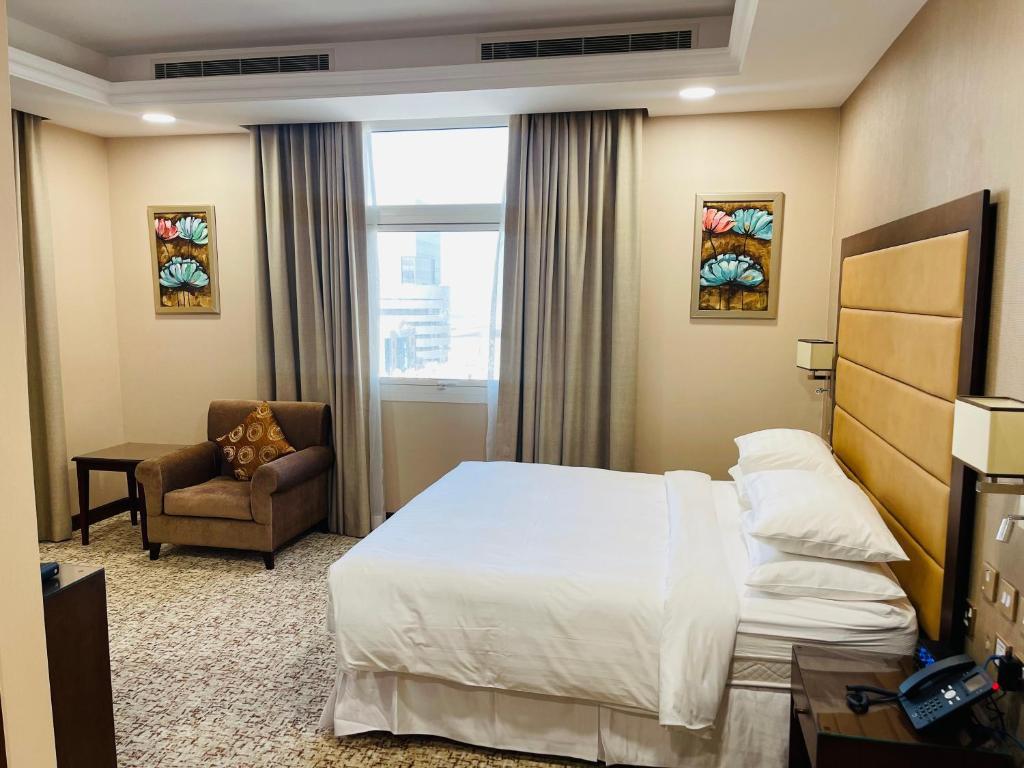 多哈Grand Legacy Hotel Doha的配有一张床和一把椅子的酒店客房