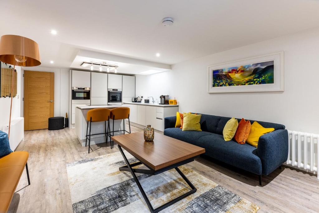 爱丁堡RÌGH Properties - Luxury West End Artisan Apartment的客厅配有蓝色的沙发和桌子