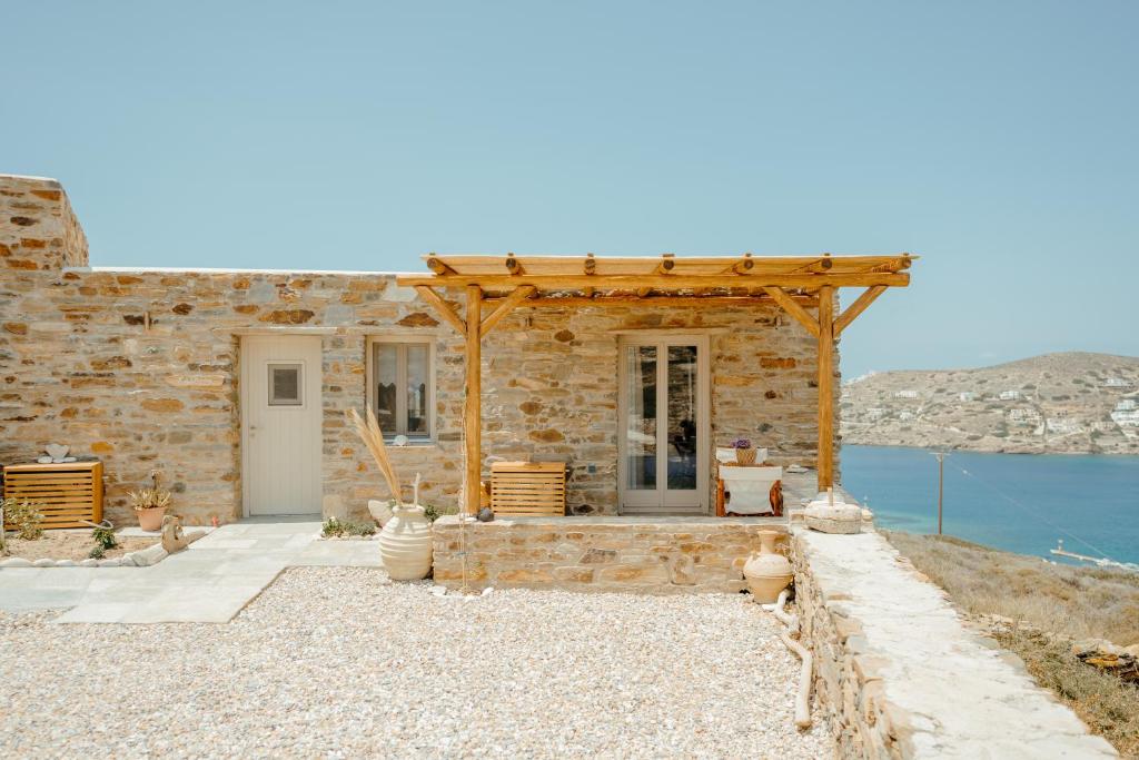 伊奥斯乔拉Heliopetra Punta的水边的石屋,设有木制凉亭