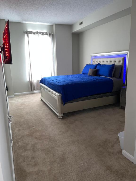 巴尔的摩Luxury penthouse apartment的一间卧室配有一张带蓝色床单的床和一扇窗户。