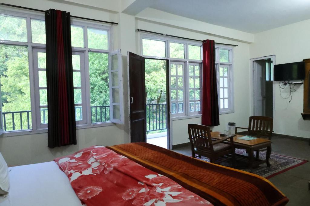 戴尔豪斯Paradise Guest House Dalhousie- Near Panchpula Water Fall的卧室配有床、桌子和窗户。