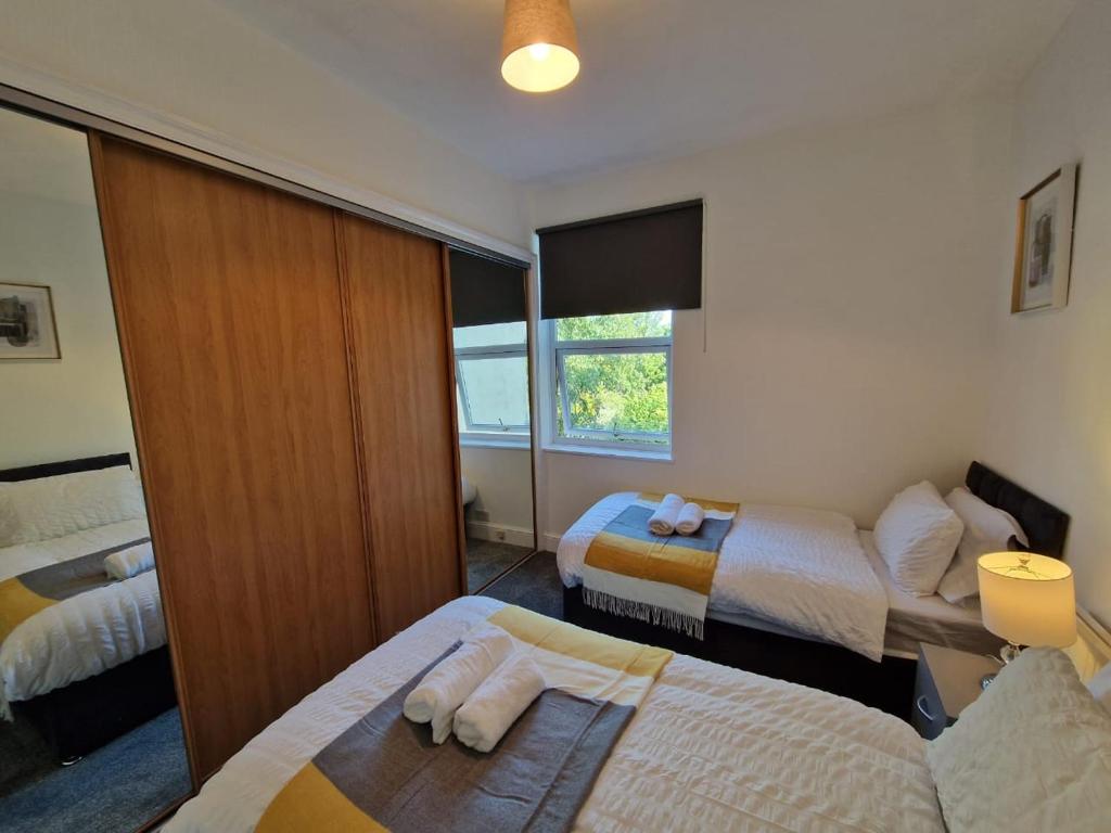 KentSwanley Guest House的酒店客房设有两张床和窗户。