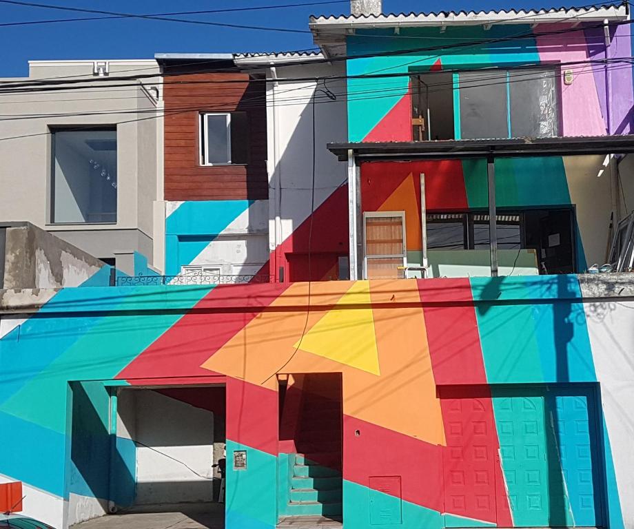 圣卡洛斯-德巴里洛切Nina Hostel的一座色彩缤纷的建筑,前面有反射